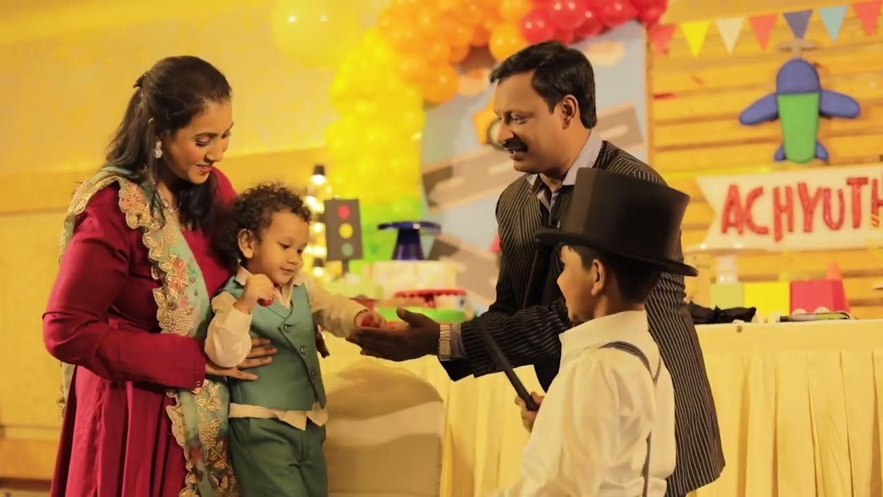 A man and woman standing next to a child at a birthday party.
